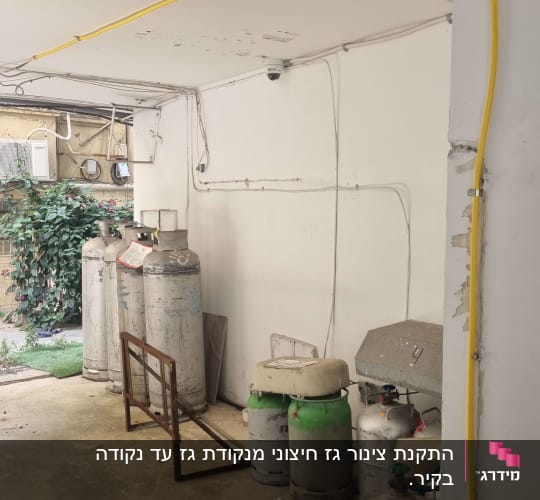 בלוני גז גדולים וקטנים בחדר עם צינורות צהובים